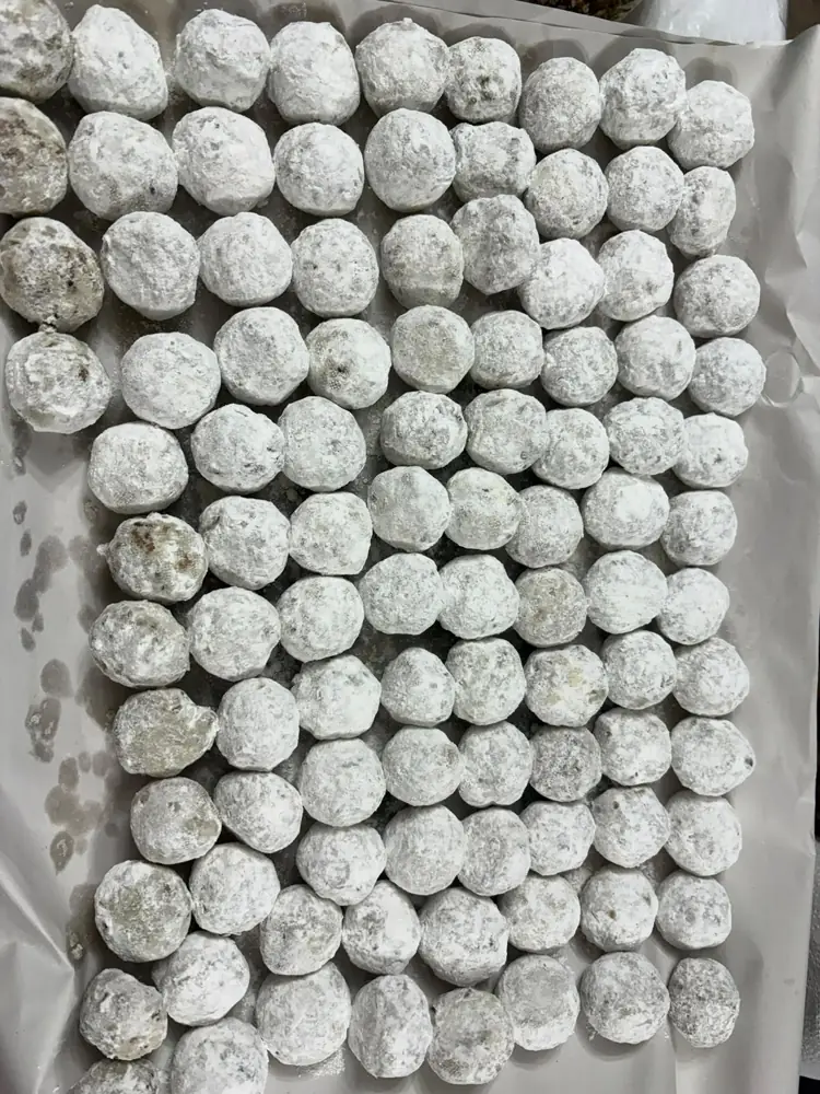 Charola de besos de nuez recién cubiertos de azúcar glass